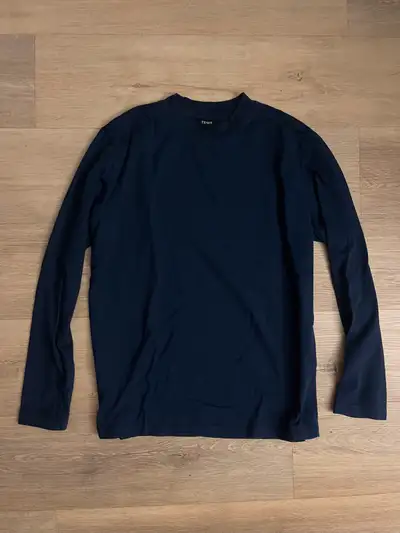 This dark blue long sleeve shirt is a versatile addition to any wardrobe, perfect for layering or we...