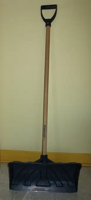 Une pelle à neige en solide polyéthylène avec une lame de 20" ou 50cm de large et un manche en bois...