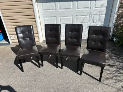 These are a set of four used dark brown parson chairs, perfect for adding a touch of elegance to you...