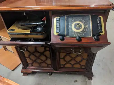 This vintage Zenith record player and radio console is a unique piece of audio history, featuring a...