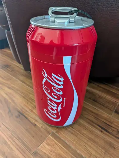 This Coca-Cola themed mini fridge is shaped like a giant can. It's a portable cooler that runs on 12...