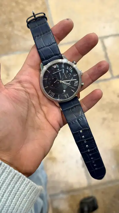 This Emporio Armani watch features a sleek design with a black dial and a stylish blue leather strap...