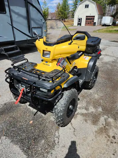 Awesome Polaris Sportsman 400 4x4 ATV. Yellow color. Has a windshield, front and rear racks, a winch...