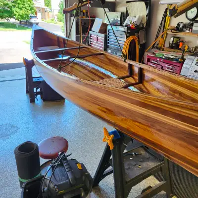 Red and white cedar strip canoe built to specks by a craftsman. 67 lb. Very stable and manageable in...