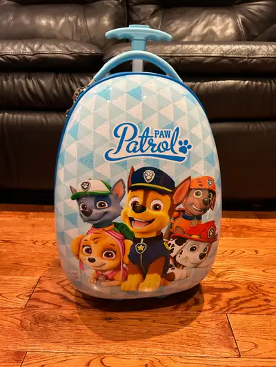 Light blue Paw Patrol rolling suitcase featuring Chase, Marshall, Skye, and Rubble. It's a fun and d...
