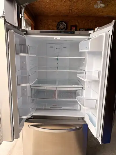 This is a used LG refrigerator in stainless steel finish with a french door configuration and a bott...