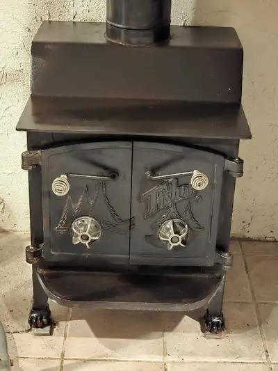 This is a Grandma Bear Fisher wood stove with cathedral doors and a top vent, ready to heat your hom...