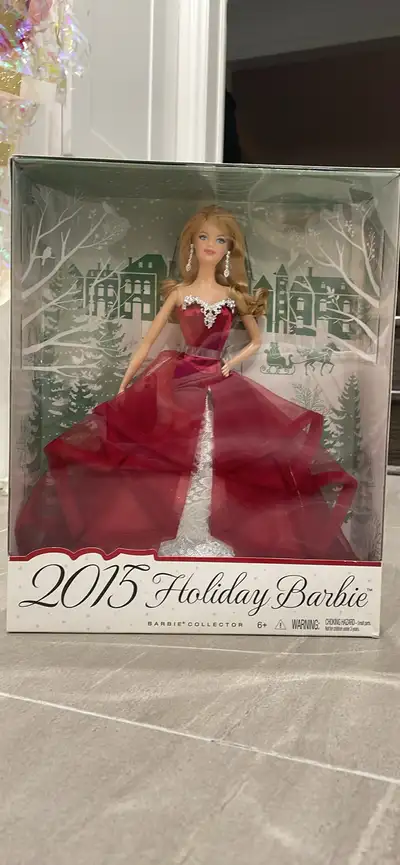 This is a mint condition 2015 Holiday Barbie Collector doll in a garnet-colored gown. The doll wears...