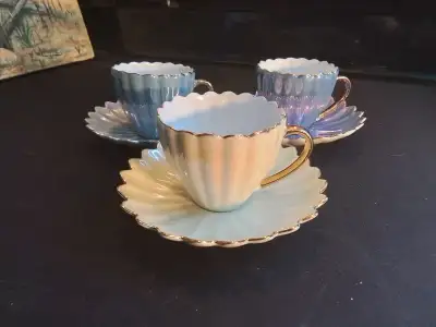 Set of three teacups and saucers. Pretty pastel colours. Gold accents. Scalloped edges. Flower-shape...