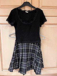 Girl's black short-sleeved top and pleated, patterned skirt