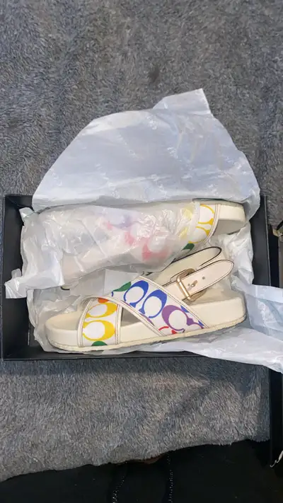 Selling a pair of Coach women's sandals in a size 7! They feature a fun rainbow design with the Coac...
