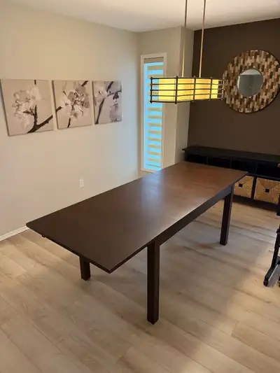 Large IKEA dining-room table with a dark brown finish and two removable extension leaves. Use it at...