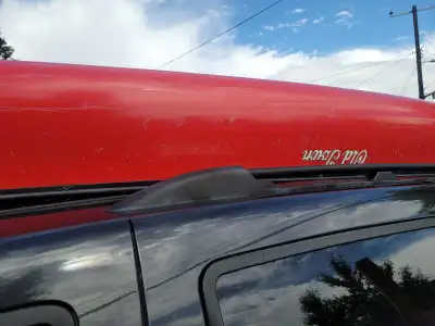 This reliable red Old Town canoe is ready for your next water adventure, showing moderate signs of w...