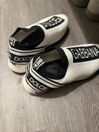 Step out in style with these Dolce & Gabbana slip-on sneakers, featuring a sleek white design with b...