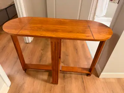 This elegant wooden hall table features a classic design with a smooth, rounded-edge top and sturdy,...