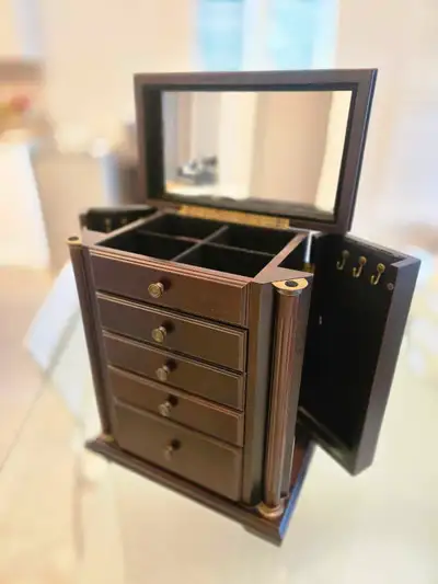 This is a lovely, used, dark wood jewelry box with a mirror, side doors for hanging necklaces, and s...
