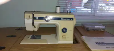 Machine a coudre Kenmore , meuble inclus ( 3 tiroirs) Plusieurs fonctions , parfaite condition. Cont...