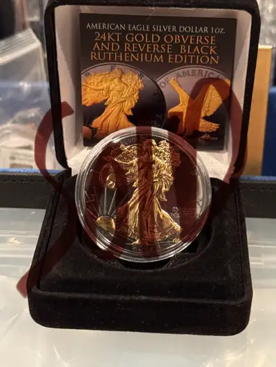 Selling an American Eagle Silver Dollar 1oz coin. It features 24KT Gold Obverse and Reverse Black Ru...