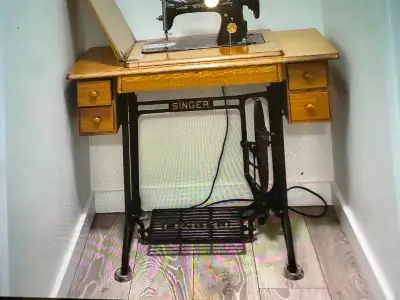 Antique singer pedal sewing machine in pristine condition. Includes manual, all attachments, origina...