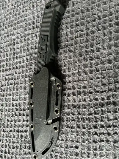 I'm selling a new SOG Field knife with a partially serrated edge, known for its durability and versa...