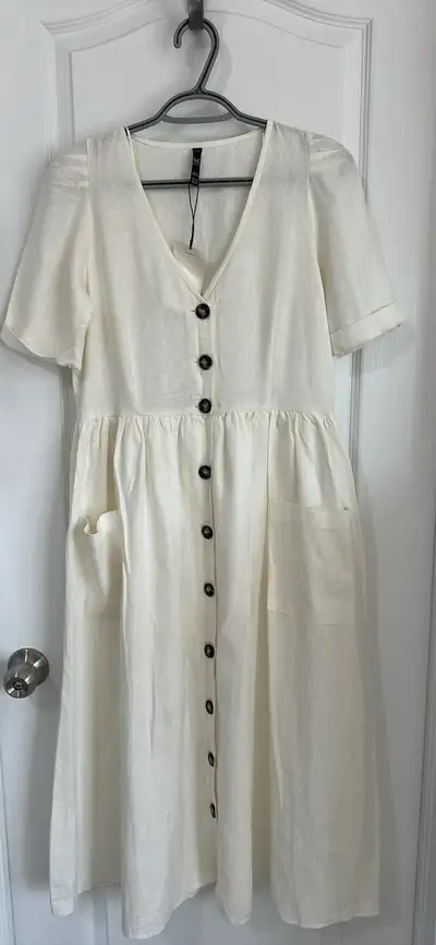 This is a brand new beige Zara dress, perfect for a casual or semi-formal occasion. It features a fl...