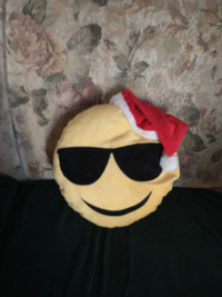 Sunglasses emoji pillow wearing a Santa hat