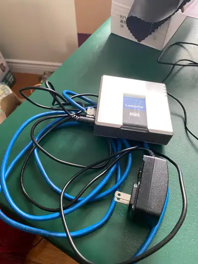 The Cisco/Linksys SPA2102-R is a VoIP (Voice over Internet Protocol) phone adapter with a built-in r...