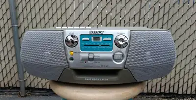 The Sony CFD-V7 is a classic, portable analog boombox featuring a top-loading CD player, a single ca...