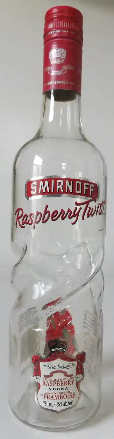 This is an original vintage empty Smirnoff Raspberry Twist vodka glass bottle. The glass has 4 inden...