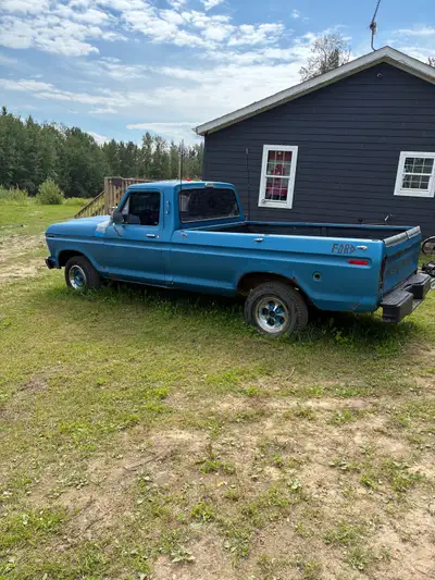 This 1976 Ford F100 is a classic, project-ready pickup truck featuring a rugged blue exterior and a...