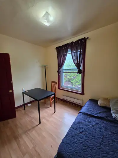 GRANDE chambre meublée un lit simple, une table et une chaise dans 6 et demi au dernière étage d'un...