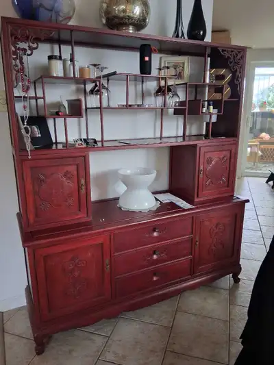 Admirez ce vaisselier rouge foncé, un meuble de rangement qui marie fonctionnalité et esthétique ave...
