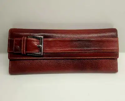 Red leather women's clutch wallet with a buckle accent., View more