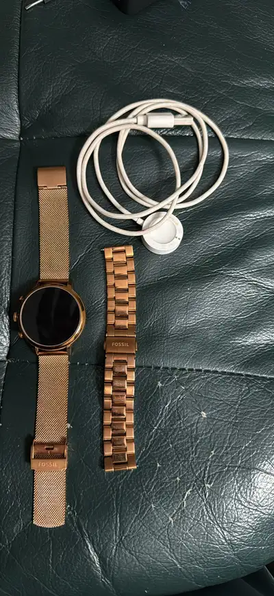 This is a used Fossil women's smartwatch, complete with an extra rose gold mesh belt for versatile s...