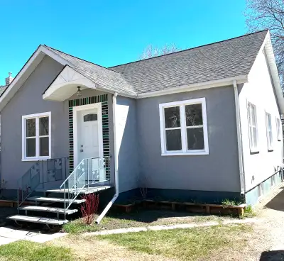 Updated single-family home has grey stucco exterior with all new windows and matching detached garag...