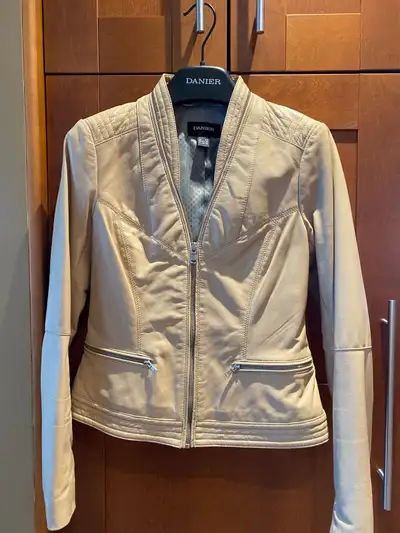This Danier leather jacket is a stylish and versatile addition to any wardrobe, featuring a unique d...