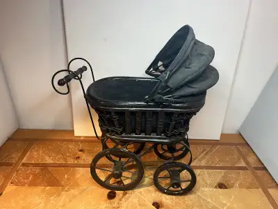 Victorian style doll pram . Mounted on an iron frame the whicker basket has a canvas bottom and umbr...