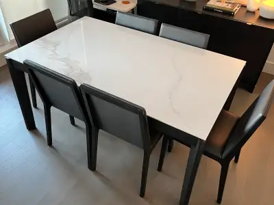 This Huppe dining table comes with six chairs and features a stylish white, marble-look top and slee...