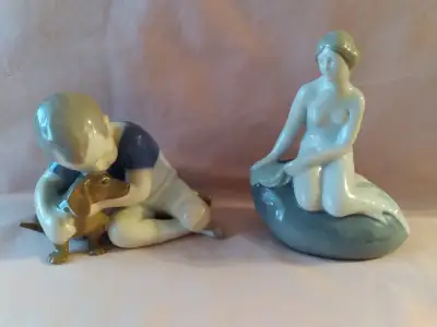 A beautiful pair of vintage, German figurines of a mermaid sitting on a rock, and a boy with his lov...