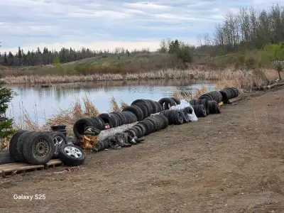 Clearing out a large collection of used tires of various sizes and conditions, perfect for a variety...