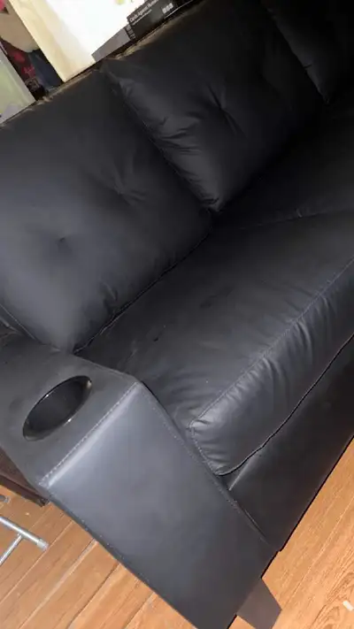 This is a brand new black leather couch, perfect for any living room. It's in good condition and fea...
