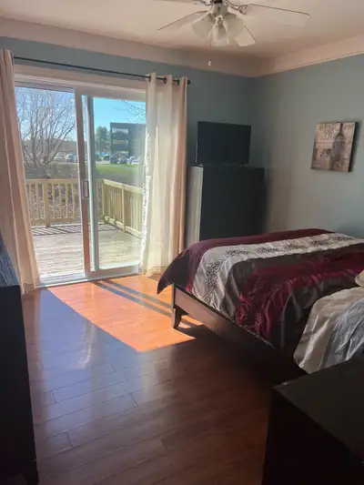 This bedroom faces the water with a patio door and deck facing the river for rent next to college. T...
