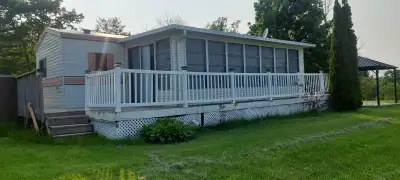 For sale Late 1980s Kropf Park Model Trailer with Large Screened in Sunroom located in Heritage Park...