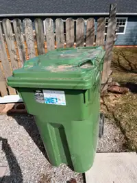 Slightly used green garbage bin