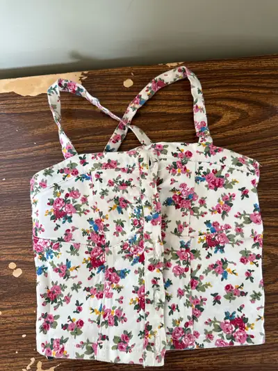Adorable floral print crop top. Features thin straps that cross in the back. Button closure down the...