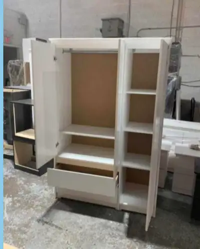 This brand new wardrobe offers ample storage with a rod for hanging clothes, multiple shelves, and a...