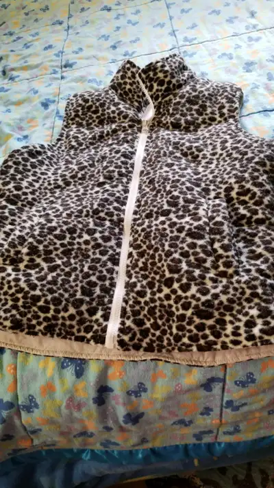 I'm selling a cute little women's outdoor vest. It's reversible. White on one side and a leopard pri...