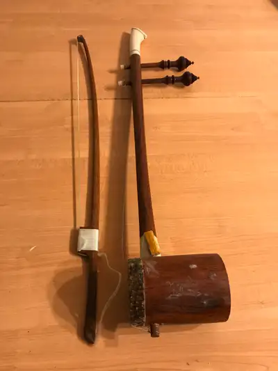 The object in the image is a traditional Southeast Asian spike fiddle, likely a Cambodian Tro Sau or...