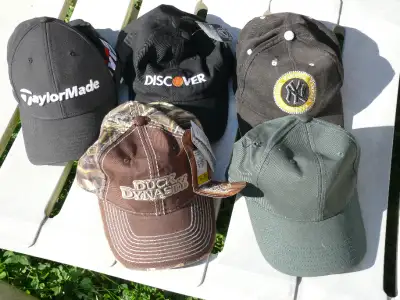 Variety of baseball hats. Some new with tags attached, some new without tags. Discovery one has a ma...