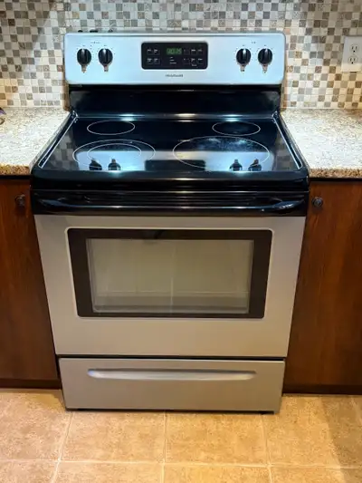 Four cuisinière électrique, de marque Frigidaire et en vitrocéramique. En bonne condition, tout est...